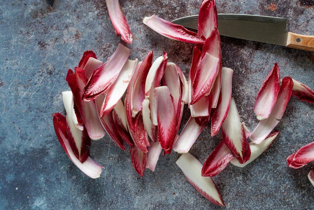 Close-up of sliced red chicory on rustic surface, ideal for healthy cooking concepts.